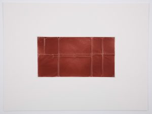 Red surface with creases in a linear fashion.