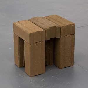 Stool like structure composed of bricks.