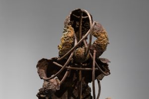 Back view of the bronze sculpture showing the wires holding the fragmented body parts together.