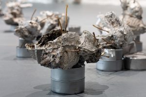 Detail view of the tuna cans and bread pieces sprayed in aluminum.