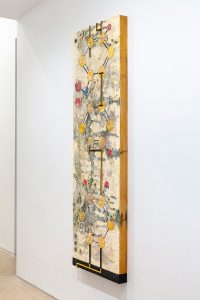 Tall painting with a bumpy textured surface with metal roads going across.