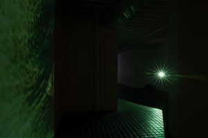 Gallery view directly facing the green hued beams of a projector.