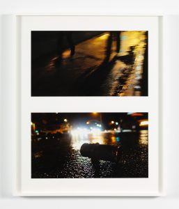 Two photographs of dark streets, street lights, and various reflections of urban landscape in white frame