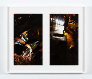 Two photographs of dark streets, street lights, and various reflections of urban landscape in white frame
