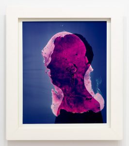 Side profile of the silhouette of a figure from the shoulders up in a blue background with a pink, sheer abstracted layer on top covering the figure's head and neck.