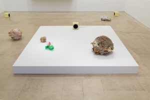 Gallery space with sculptures and speakers
