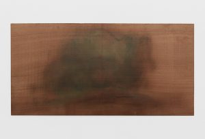 Green and brown abstract forms on wooden carved panel.