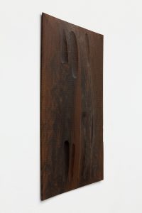 Side view of dark wooden panel.