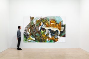 Person standing to the left, looking at an abstract painting.