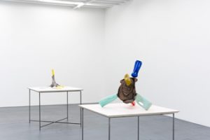 Installation view of two sculptures on tables.