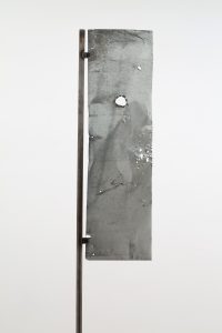 Detail of previous sculpture, an aluminium leaf with small and irregular holes strung onto a flagpole.